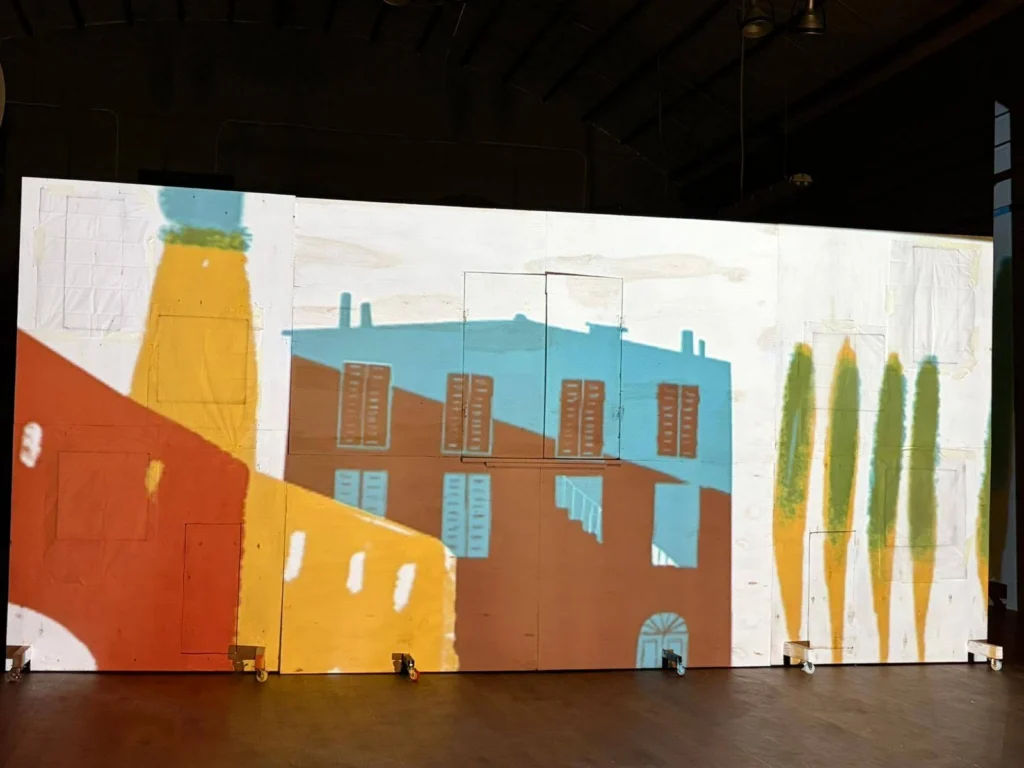 Videoproiezione di una città colorata sulla scenografia del Teatro Nuovo