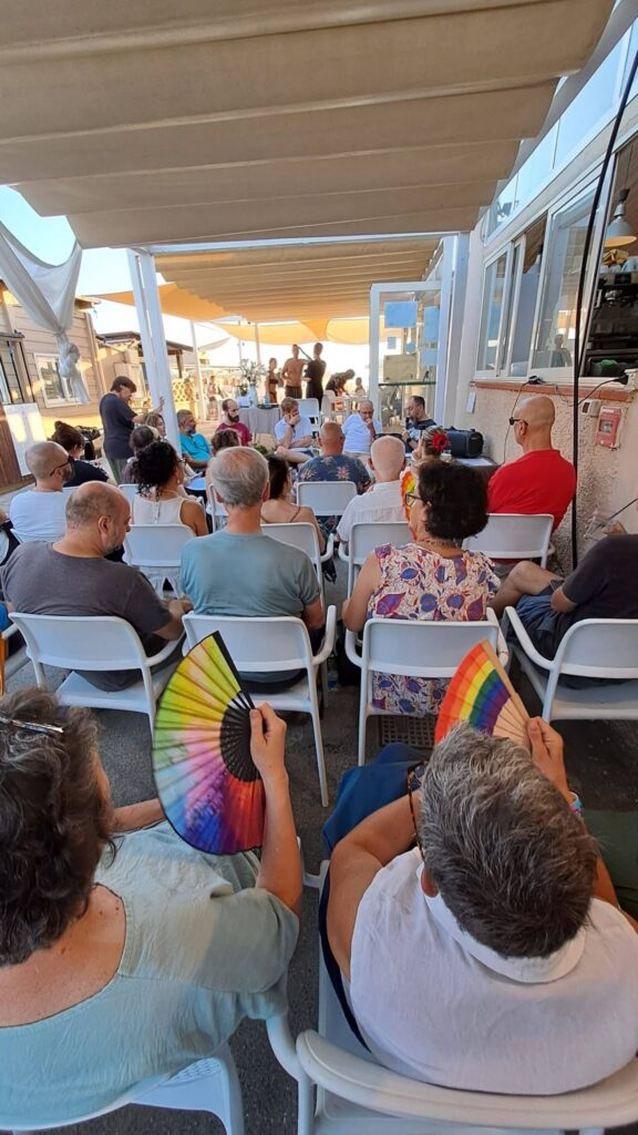 Una spettatrice con un ventaglio arcobaleno durante la presentazione