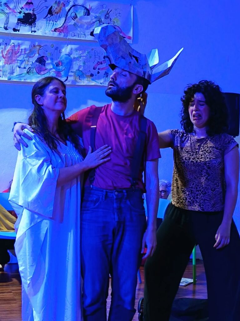 Tre interpreti in scena, uno con la testa d'asino